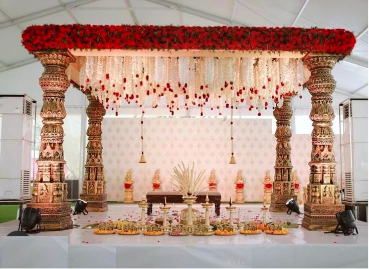 The sacred fire ringed with marigold garlands and ritual objects in warm darkness