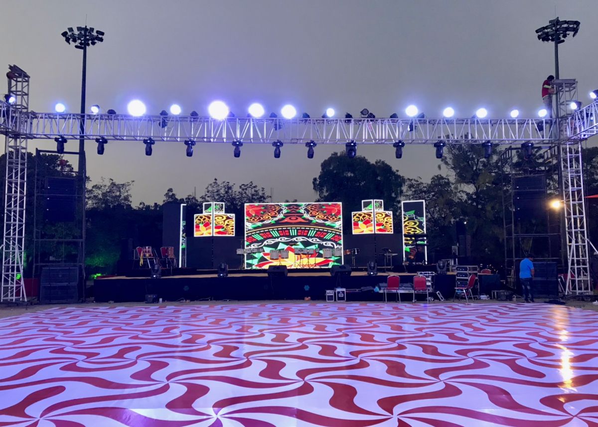 Dancing feet and lehenga hems caught in motion blur under warm stage light